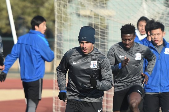 Football player Carlos Tevez attends a training session with team members of Shanghai Greenland Shenhua Football Club in Shanghai